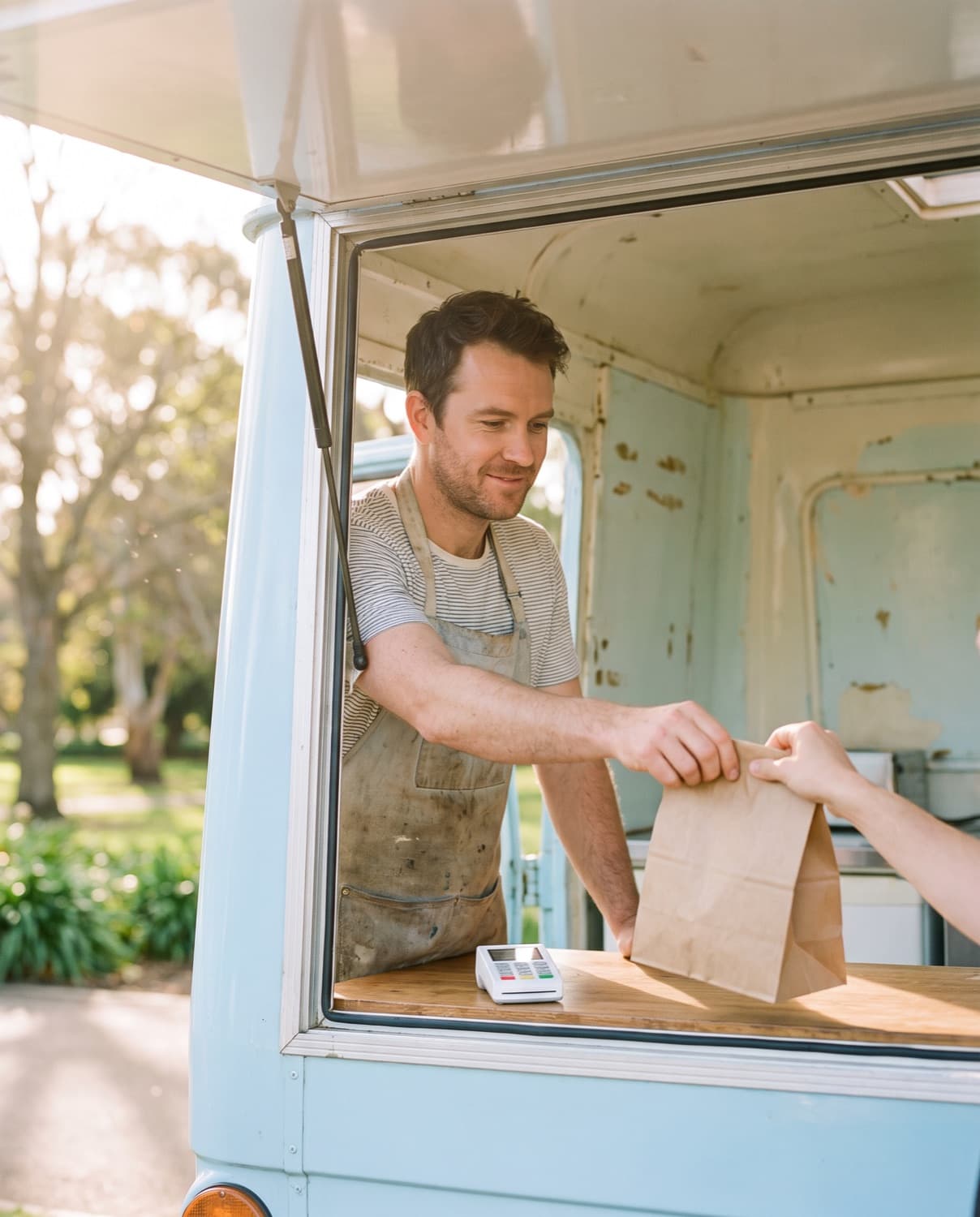 A food truck owner handing an order through the window